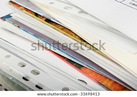 Big pile of different coloured office papers in files and folders on white background