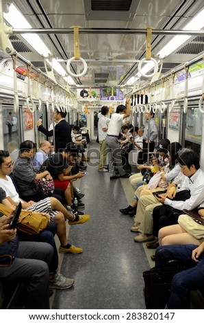 Tokyo, Japan - September 17, 2013: The interior of a subway train carriage in Tokyo, Japan. Passengers are seen sitting, standing and even sleeping in the train.