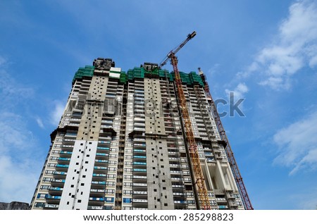 Singapore - May 30, 2013: A high rise condominium building under construction. The photo shows a crane working. Land scarce Singapore uses skyscrapers to house its people and economize on land use.