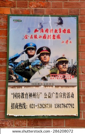 Shanghai, China - February 11, 2013: A recruitment poster of the Chinese armed forces glorifying military service. The poster was pasted to a wall in a residential neighborhood of Shanghai, China.