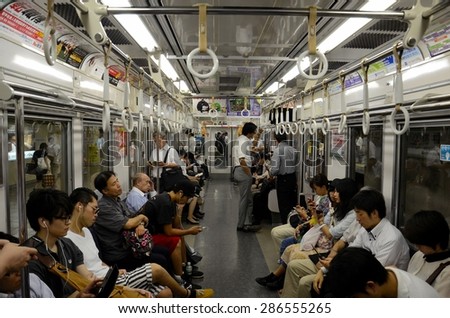 Tokyo, Japan - September 17, 2013: The interior of a subway train carriage in Tokyo, Japan. Passengers can be seen sitting, standing and even sleeping in the train.