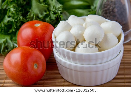 Mini mozzarella in ceramic cup with tomato, lettuce and pepper
