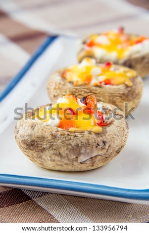 Baked mushrooms stuffed with cheese and vegetables on plate
