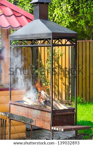 Big brazier with fire and ember for barbecue picnic in backyard of country-house