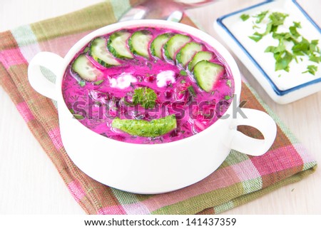 Funny healthy traditional cold Lithuanian summery soup made of beets, cucumbers, egg and herbs for children