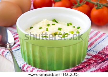 Whipped steam eggs in a cup with green onions for breakfast