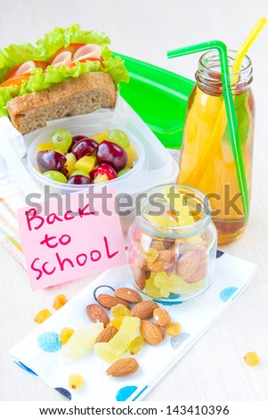 Bento lunch for your child in school, box with a healthy sandwich and fruit salad and apple juice in the bottle for drinking