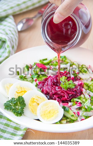 Traditional cold Lithuanian summery soup made of beets, cucumbers, egg and herbs with pour out beetroot juice