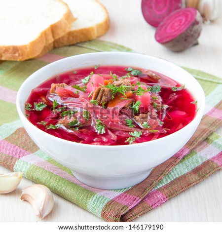 Rich meat traditional Russian borsch soup with beef, beet, potatoes and cabbage in white bowl for dinner