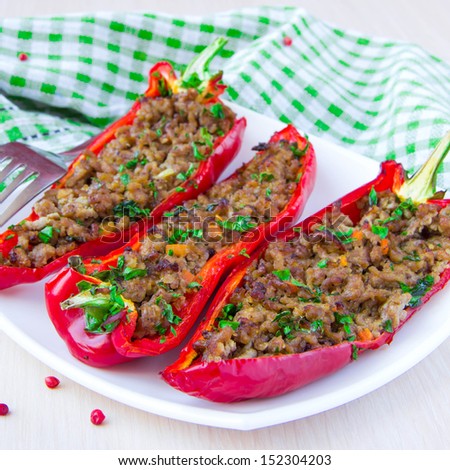 Stuffed red pepper with meat, carrot and parsley on plate, tasty meal