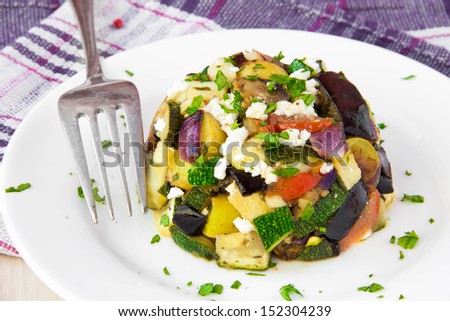 Restaurant appetizer of baked vegetables: eggplants, zucchini, potatoes, tomato and onion with feta cheese