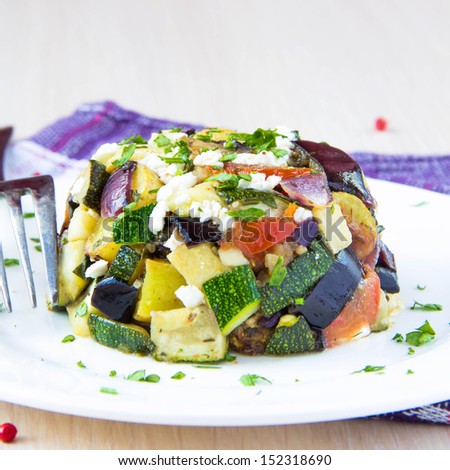 Restaurant appetizer of baked vegetables: eggplants, zucchini, potatoes, tomato and onion with feta cheese