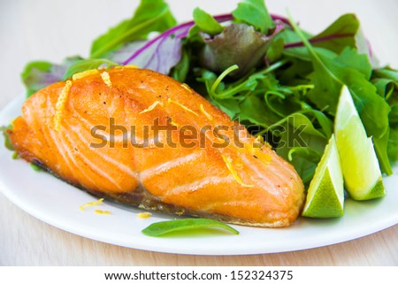 Grilled fillet of red salmon and salad with green leaves of lettuce and spinach, tasty dish