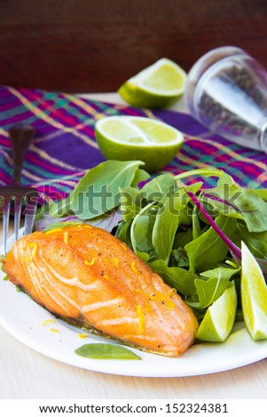 Grilled fillet of red salmon and salad with green leaves of lettuce and spinach, tasty dish