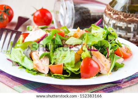 Delicious fresh salad with salmon, lettuce, cherry tomatoes and herbs, tasty snack