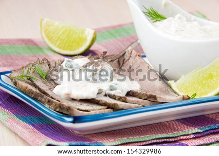 Thinly sliced veal meat with white sauce mayonnaise and lime, fresh traditional dish