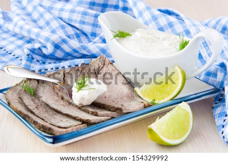 Thinly sliced veal, beef meat with white sauce mayonnaise, lime, dill