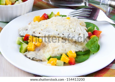 Fried filet of white fish Dorado on bed of fresh spinach and salsa with mango, cucumber and red pepper