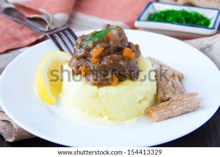 Delicious home-cooked dinner, mashed potato with stew of beef meat and gravy, beautiful presentation