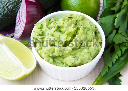 Green Mexican Guacamole Dip With Avocado, Lime, Parsley And Red Onions In White Ã?Â?Ã?ÂUp And Vegetables Around