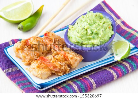 Grilled prawns in breadcrumbs and green sauce, guacamole with avocado, red onions, parsley and lime