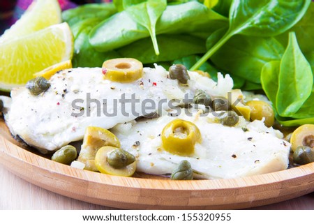 Baked filet of white fish sea bass with olives, capers, olive oil and wine, as gourmet appetizer, diet meal