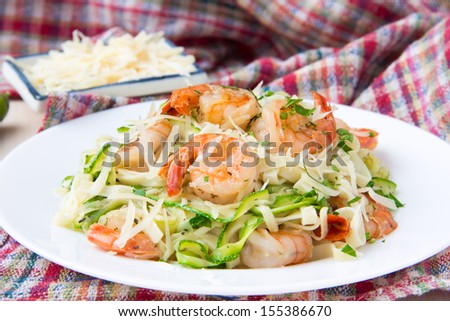Tagliatelle pasta with fried shrimps, cheese Parmesan, parsley and zucchini ribbons, handmade dish