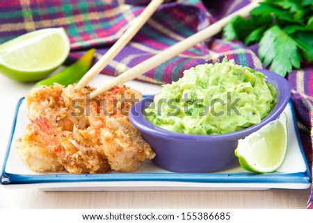 Grilled prawns in breadcrumbs and green sauce, guacamole with avocado, red onions, parsley and lime