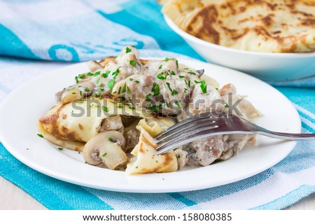Russian pancakes with chicken and mushrooms champignon with white sauce, shrovetide