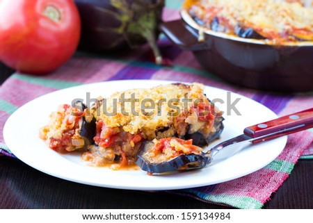 Tasty Italian dish, appetizer with eggplant, cheese and tomato sauce, portion on plate