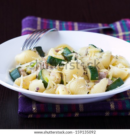 Pasta with tuna, zucchini, sauce and herbs on plate, delicious dinner