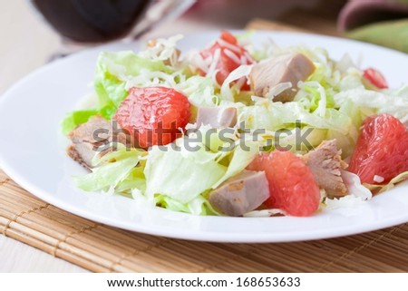 Tasty fresh salad with grapefruit, chicken, lettuce, cheese and sauce, healthy dish