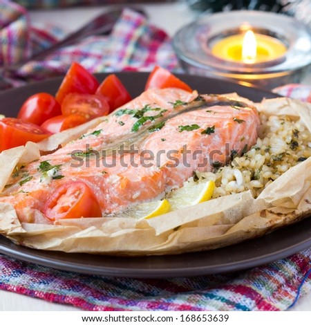 Salmon steak with rice, herbs, tomatoes, baked in parchment paper, tasty dinner