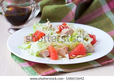 Tasty fresh salad with grapefruit, chicken, lettuce, cheese and sauce, healthy dish