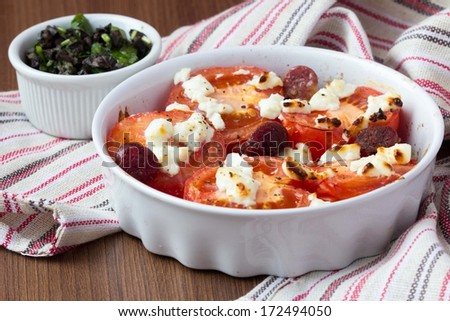 Tomatoes baked with cheese feta, smoked sausages, herbs, olives, Mediterranean tasty dish