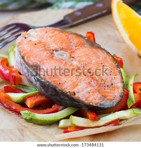 Steak red fish salmon on vegetables, zucchini, sweet pepper, orange, delicious homemade dish