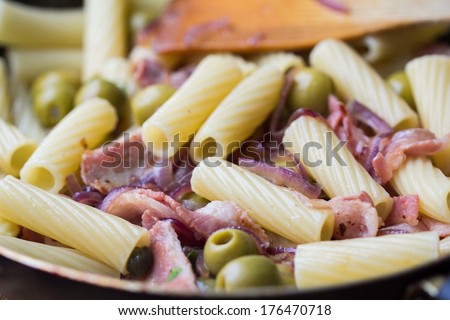 Rigatoni pasta with bacon, green olives, feta cheese, red onion, capers, delicious homemade dinner