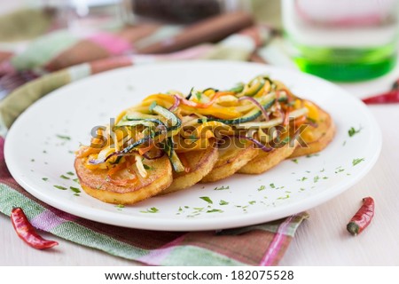 Fried slices of potato with finely chopped sticks vegetables, lean, vegetarian dish for dinner