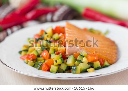 Fried fillet of red fish salmon with roasted vegetables, zucchini, pepper, beautiful dish
