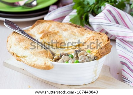 Meat pie with stew of chicken, mushrooms, peas, puff pastry crust, tasty homemade dish