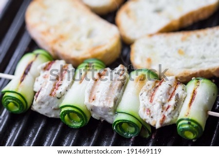 Cooking grilled chicken kebab, shashlik on skewers with rolled zucchini, toast, tasty dish
