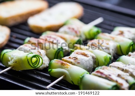Cooking grilled chicken kebab, shashlik on skewers with rolled zucchini, toast, tasty dish