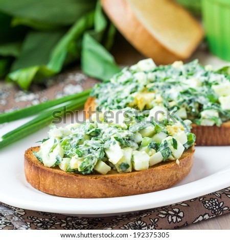 Sandwich with salad of eggs, green herb, parsley, ramson, spring onions, sauce, summer lunch