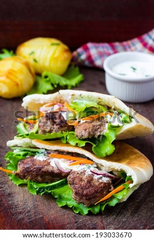 Minced meat kebab, beef balls in flat cake with vegetable, white sauce, spring picnic, Greek gyros