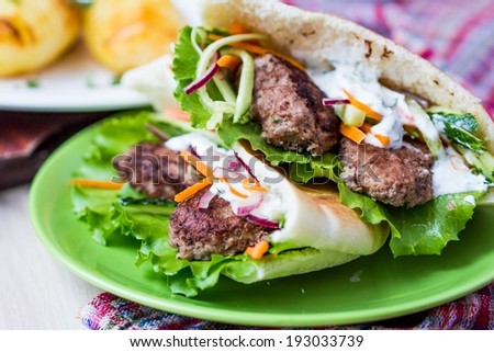 Minced meat kebab, beef balls in flat cake with vegetable, white sauce, spring picnic, Greek gyros