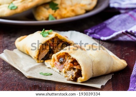 Mini calzone, closed pizza, Italian pastry stuffed with cheese, meat, tomato sauce, tasty dish