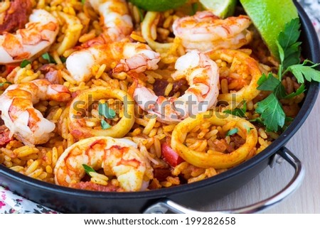 Spanish dish paella with seafood, shrimps, squid, rice, saffron, traditional tasty dinner