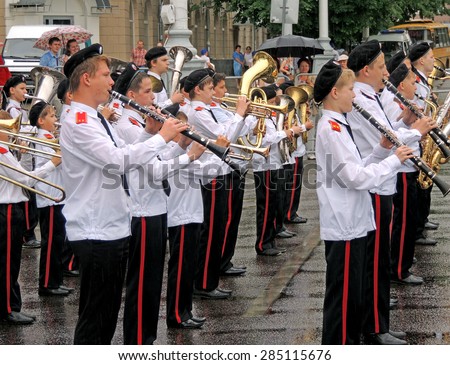 Marching band of youth pupils on the Music Festival of Children\'s Brass Bands on the city central square in a rainy day in Voronezh, Russia, May 31, 2015