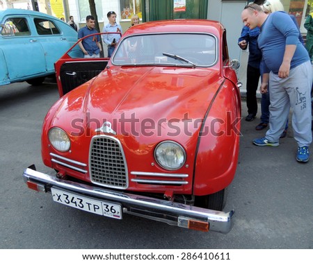 Voronezh, Russia - May 9, 2015: City dwellers look round sweden retro car of 1950s front-wheel drive coupe Saab 93 on the street near city central square during the celebration of the Victory V-E Day