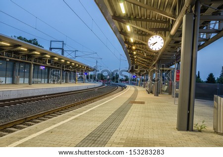 An empty railway station with a clock in evening.